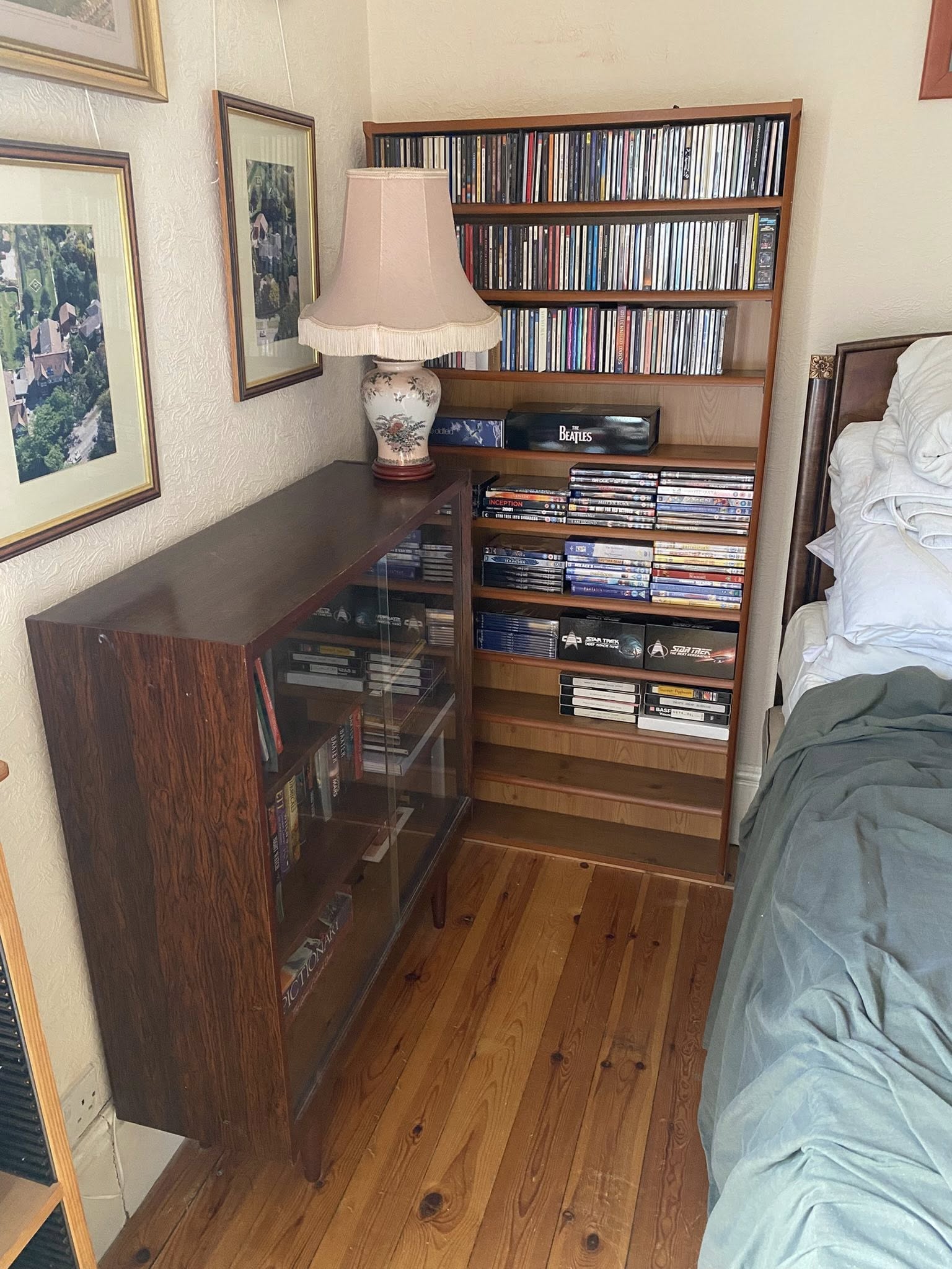 Organised bedroom shelving with books and media neatly arranged